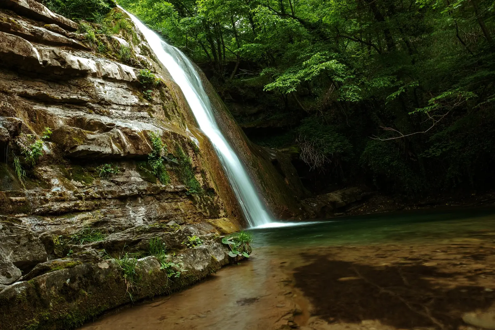 Il salto d’acqua della cascata dell’Acquacheta tra le rocce e il bosco