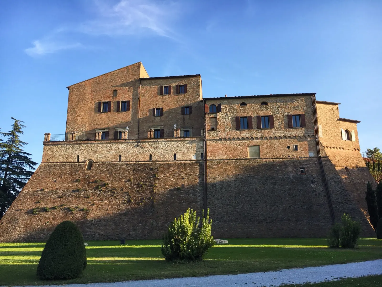 Le mura in pietra della rocca di Bertinoro tra gli alberi
